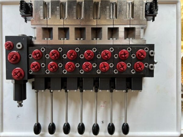 A machine with many red knobs and black handles.